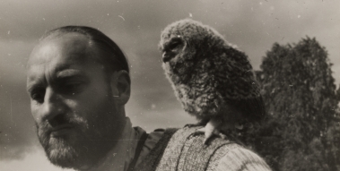 Graphics in gray tones. It depicts Wlodzimierz Puchalski with a bird perched on his nose. 