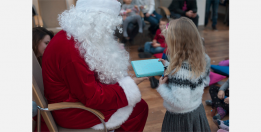 Santa presents a gift to a child. 