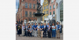 A group of people pose for a photo. Neptune's Fountain in Gdansk in the background. 