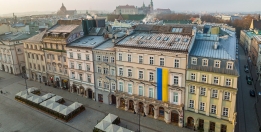 An aerial view of the townhouses, including the ICC headquarters. A large flag of Ukraine is hung on the facade. 