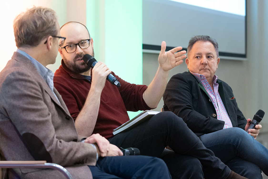 Na scenie siedzą: Maciej Czerwiński, w środku Grzegorz Wysocki, który przemawia do mikrofonu, obok Robert Makłowicz.