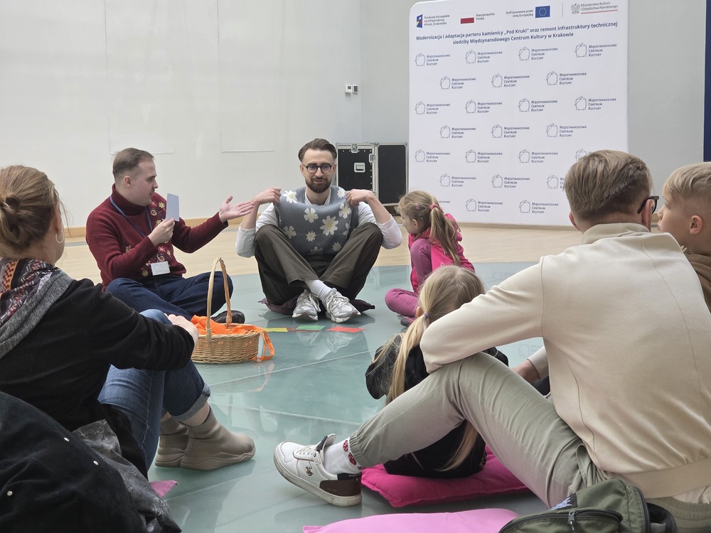 Prowadzący rozmawiają z dziećmi i rodzicami podczas interaktywnych warsztatów.