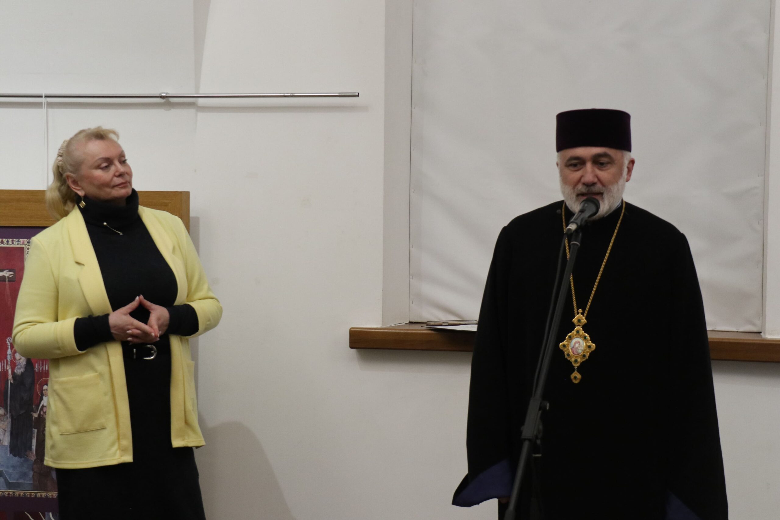 Wersniaż. Przemawia Pop. Obok stoi kobieta i przysłuchuje się.