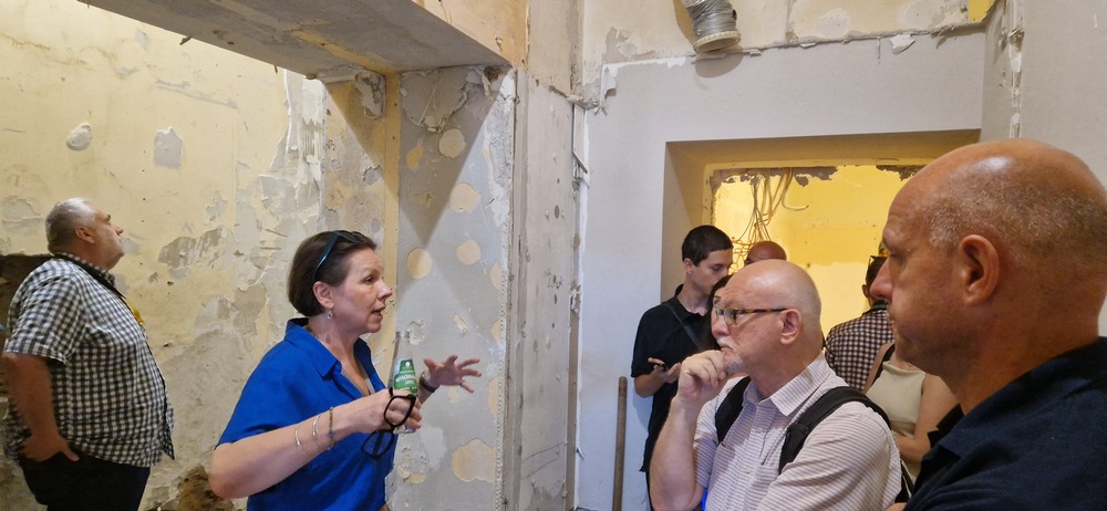 Grupa dziennikarzy i dziennikarek w holu MCK rozmawia z dyrektorką Agatą Wąsowską-Pawlik.