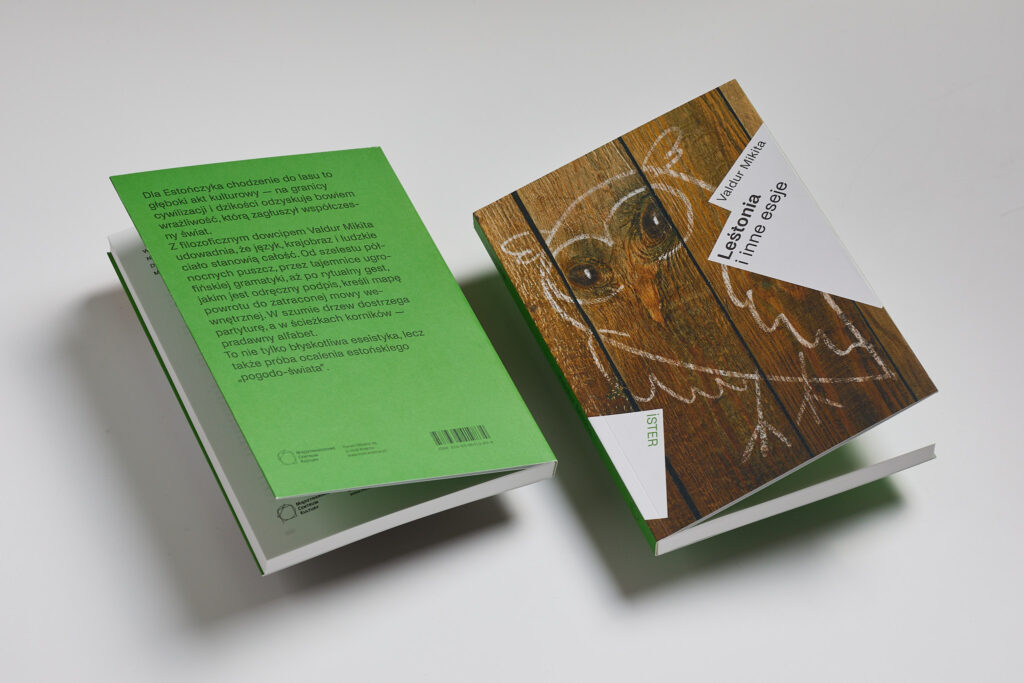 Two copies of Valdur Mikita’s book Leštonia i inne eseje shown with their green dust jackets unfolded. The owl illustration on a wooden background and the text on the back of the jacket are visible.