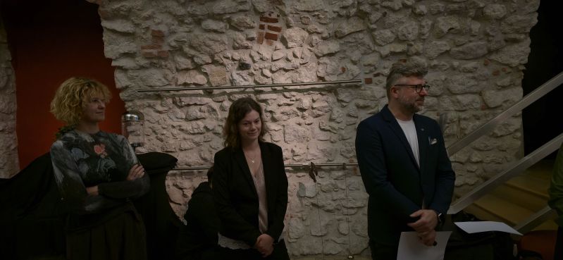 Marzena Daszewska wraz z uczestnikami IV Akademii Dziedzictwa dla Ukrainy podczas spotkania poświęconego sztucznej inteligencji i nowym technologiom w instytucjach kultury. Grupa stoi w zabytkowym wnętrzu z kamiennymi ścianami podczas jednej z części programu.