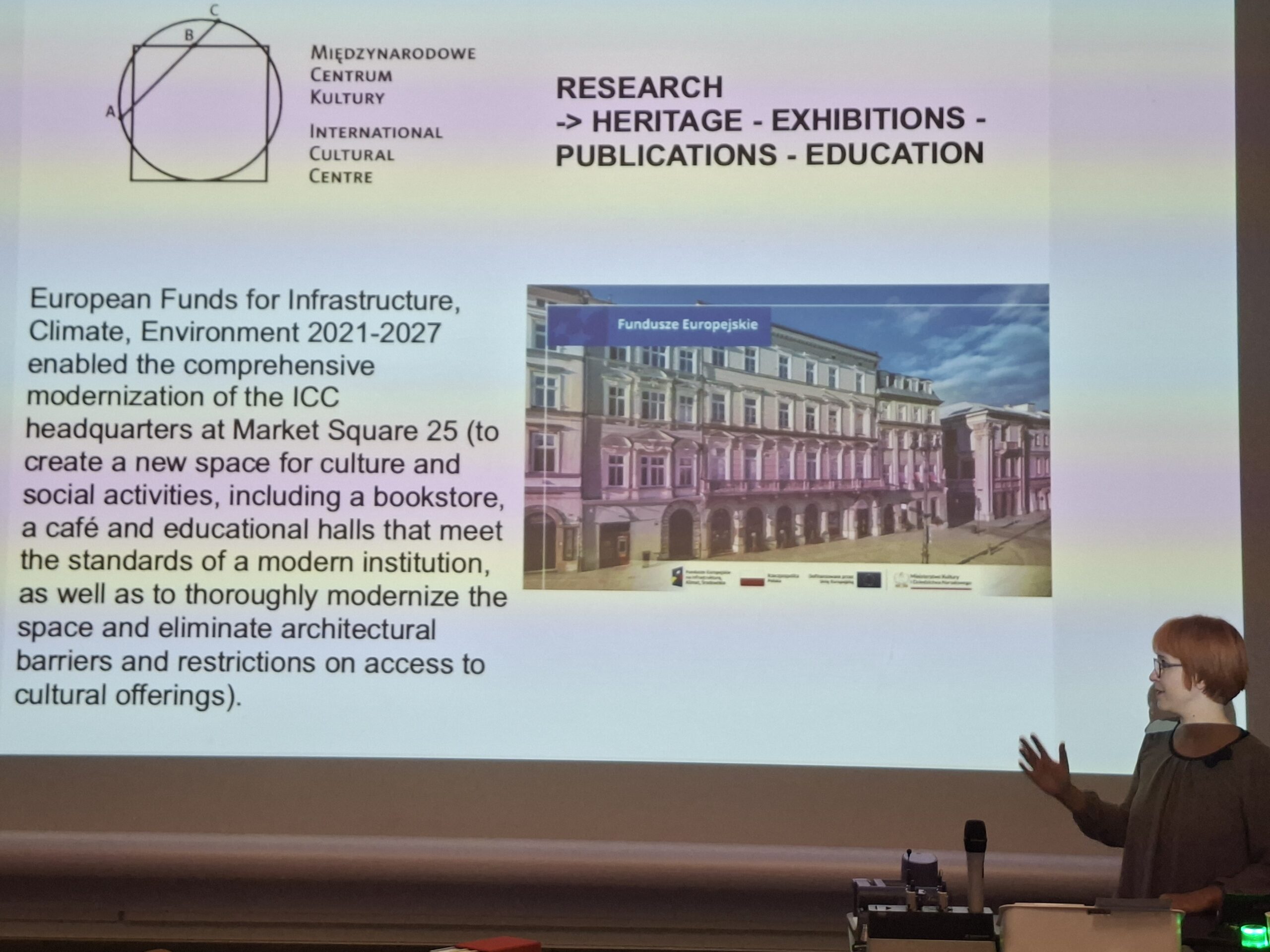 Magdalena Łanuszka podczas prezentacji na zjeździe RIHA 2026. Na ekranie widoczny jest slajd Międzynarodowego Centrum Kultury dotyczący modernizacji siedziby MCK przy Rynku Głównym 25 w Krakowie, realizowanej dzięki środkom z programu Fundusze Europejskie na Infrastrukturę, Klimat i Środowisko 2021–2027.